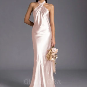 Champagnefärgad balklänning i satin med halterneck - Riktigt snygg rosa/champagnefärgad balklänning i silk/satin från Glamlora. Den har halterneck och öppen på ryggen. Storleken: bröst 30 inches, midja 25, höft 34 och har endast prövat den en gång. Säljer den då den inte passar min längd riktigt och jag är 158 cm. 🎀🩷.  