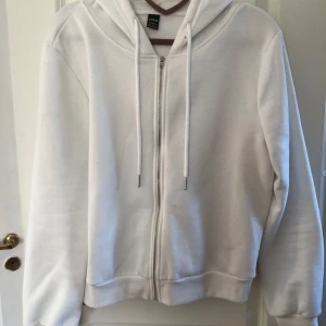 Vit hoodie med dragkedja  - Säljer en enkel och stilren vit hoodie från SHEIN i storlek M, dock skulle jag säga att den passar som en xs/s. Tröjan har dragkedja framtill, huva med dragsko och långa ärmar. Den är även lite kortare i längden 🤍