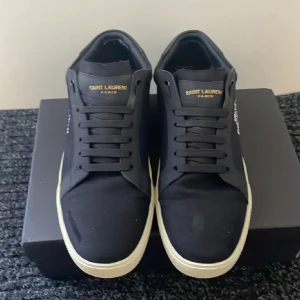 Svarta sneakers från Saint Laurent - Säljer ett par svarta sneakers från Saint Laurent box och kuvär följer med,skit snygga, säljer för att jag vill köpa nya. Skriv om du är intresserad priset är inte hugget i sten så priset kan diskuteras!