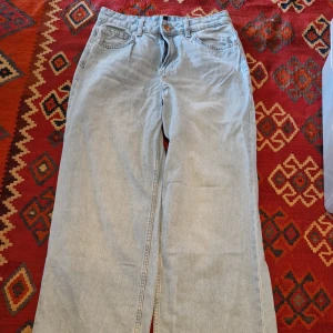 Ljusblåa raka jeans - Ljusblåa jeans med rak passform och klassisk femficksdesign. Jeansen har hög midja och stängs med dragkedja och knapp. Perfekta för en avslappnad och stilren look.