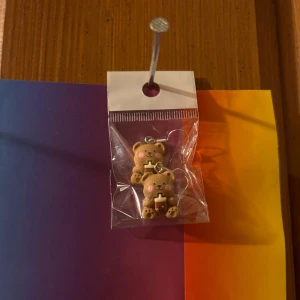 Söta björnörhängen med hjärtdetalj - Supergulliga örhängen formade som nallebjörnar med små hjärtan och korsdetalj. Perfekta för att ge din stil en lekfull touch! Kommer i förpackning.