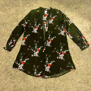 Svart blommig långärmad klänning - H&M svart klänning med lång ärm och blommigt mönster i vitt och rött. Lätt A-linjeformad passform och mjukt, följsamt material. Perfekt för dig som gillar en romantisk och somrig look☀️🌹❤️🦋