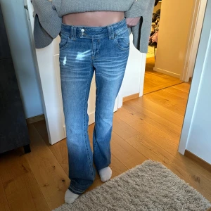 lågmidjade bootcut jeans  - Säljer dessa supersnygga lågmidjade bootcut jeans. W.28 L.32 tjejen på bilden är 170 cm, de är uppsprättade nertill så de är nån cm längre