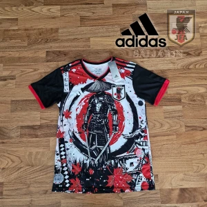 Japan Fotbollströja  - Japan Samuraj Fotbollströja – Limited Edition från Adidas. Unik tröja i storlek S, inspirerad av japansk kultur och officiellt licensierad av JFA. Design med samuraj, lönnlöv och starka färger i rött, svart och vitt. Helt ny och perfekt för fans, cosplay eller streetwear. 100 % polyester – lätt och snabbtorkande.  📦 Snabb leverans – skickas samma dag! Kontakta mig vid intresse! 📌 
