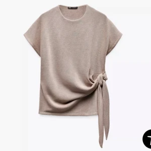 Beige topp med knyt från Zara - Säljer denna snygga zara tröjan med knyt, aldrig använd 