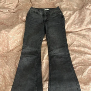 Svarta bootcut jeans - Säljer ett par svarta bootcut jeans med klassisk femficksdesign och dragkedja. Jeansen har en snygg utsvängd passform nertill och låg midja. Perfekta för dig som gillar en retrostil med modern twist.💞💞