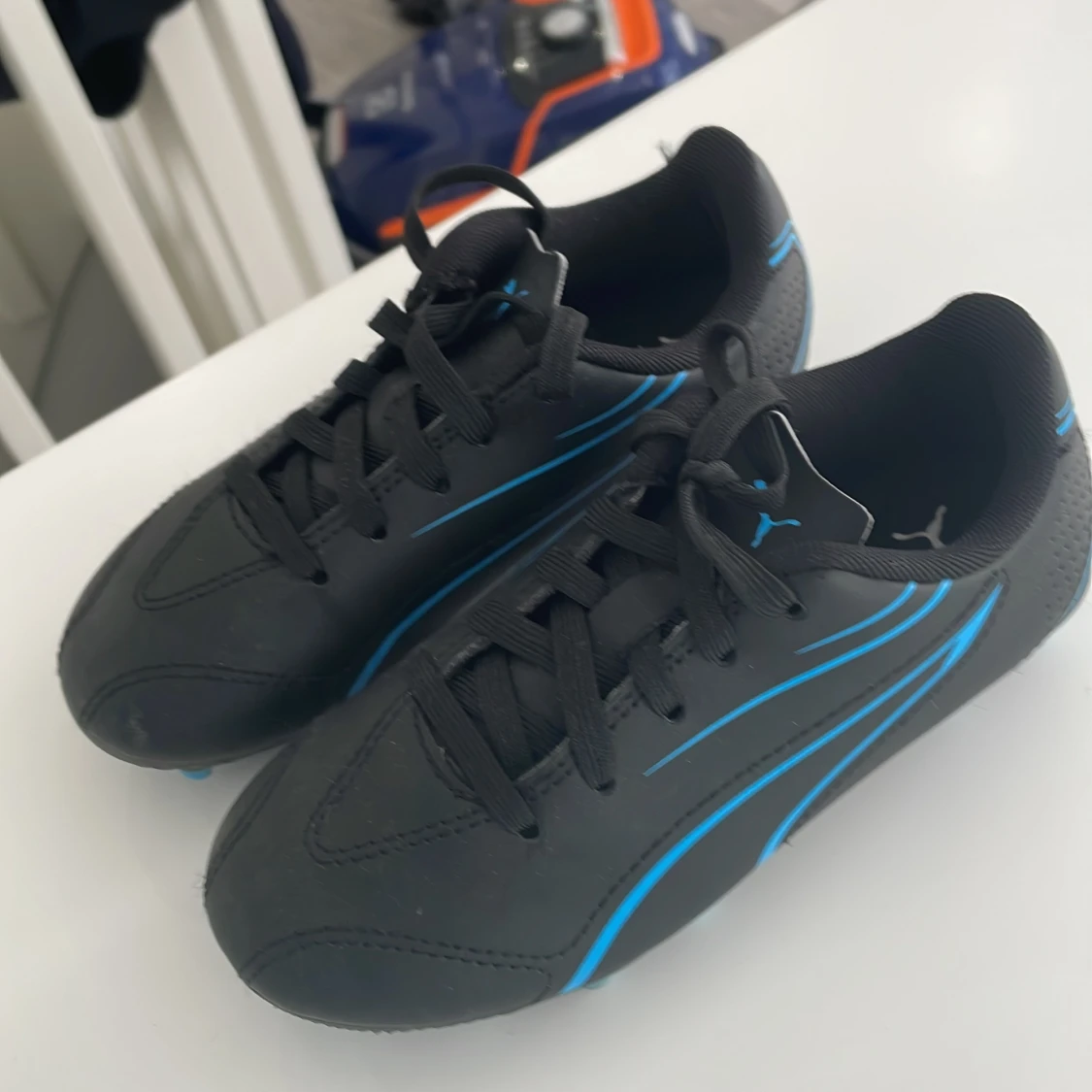 Svarta fotbollsskor från Puma med blå detaljer - 1