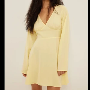 Ljusgul klänning med v-ringning från NA-KD - Söt ljusgul klänning med v-ringad hals och långa ärmar. Från NAKD, klänning är i S💕Den är i nyskick men säljer då den inte passade mig, skriv gärna vid frågor 💗