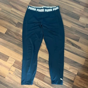Blåa tights från Puma - Säljer ett par blåa tights från Puma med bred resår i midjan där Puma-loggan syns tydligt. Tightsen är stretchiga och sitter tight
