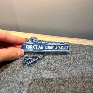 Blå Christian Dior J'Adior armband - Snyggt blått armband från Christian Dior med texten 'J'Adior' broderad i vitt. Passar perfekt för vardagsbruk. 