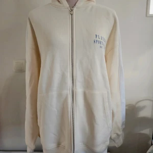 Vit hoodie Playboy x Missguided - Snygg vit hoodie med blått tryck från Playboy x Missguided. Dragkedja framtill, huva och stora fickor. Baksidan har stort sportigt tryck med tennisracketar och Playboy-logga. Perfekt för en chill och sportig vibe. Liten obehandlad fläck finns  