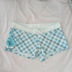 Y2k shorts - Jättegulliga rutiga y2k shorts jag köpte på vinted med 3 blommor och gulliga detaljer på sidan om men som tyvärr var förstora 😔Midjemått:43cm, bara testade av mig, oklart om storlek och så eftersom lappen är bortklippt men skulle gissa mellan S-M. Första bilden är lånad, har redan kollat lite ifaöl de är från Shein eller nått sånt men jag hitta inga som liknar dom här så de är inte ”fast-fashion” som det kallas för. Skriv för mer frågor 🤗🤗
