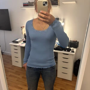 Ljusblå ribbad topp från Rosemunde - Supersöt ljusblå långärmad topp från Rosemunde med ribbad struktur och spetsdetaljer runt den v-ringade halsen. Helt ny, jag fick denna i födelsedagspresent men användes ändå aldrig, priserna på rosemunde går fårn 500-650 beroende på ställen och tid🥰 Denna ger också en riktigt bra snatch 🤏🏻 här kan priest såklartttt diskuteras 🥰