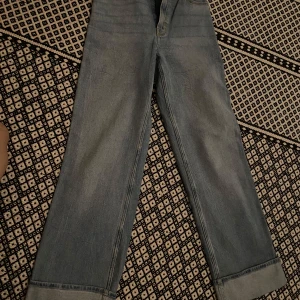 Ljusblå wide jeans från Hollister - Säljer ett par ljusblå jeans från Hollister med ultrahög midja och breda ben. Jeansen har klassisk femficksdesign, uppvikta benslut och är gjorda i mjukt denim med lite stretch. Perfekta för en avslappnad och trendig look.