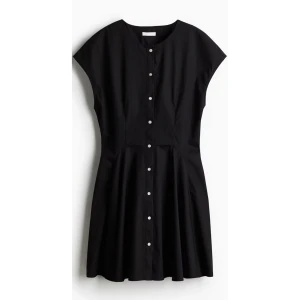 Svart kort klänning med knappar - Supersnygg svart klänning med kort ärm och rund hals. Modellen är kort och har en lätt utställd kjol. Snygga vita knappar framtill ger en cool kontrast. perfekt för dig som gillar minimalistisk stil med edge. Ny med prislapp