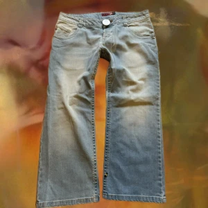 Blend ljusblå Capri jeans  - Säljer ett par ljusblå Capri  jeans från Blend med klassisk femficksdesign och stor silverfärgad knapp framtill. Jeansen har låg midja, tillverkade i mjukt denimtyg. Snygga detaljer på bakfickorna. Rakt över höften 47cm, innerbenslängd 62.