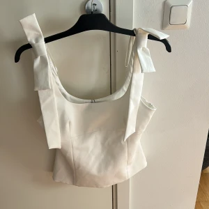 Vit linnetopp med rosettband - Söt topp från Zara med dragkedja på sidan,som ej är använd.