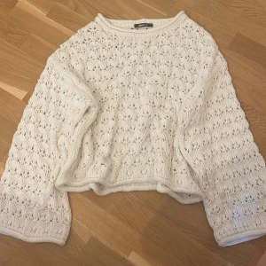 Vit stickad tröja från Gina Tricot - Superfin vit stickad tröja från Gina Tricot med snyggt hålmönster och lite vidare ärmar. Perfekt till jeans eller kjol för en chill och trendig look. Tröjan har rund halsringning och är riktigt mjuk och skön att ha på sig.