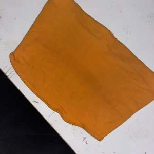 Gul tubtopp från H&M Basic - Säljer en enkel och snygg gul tubtopp från H&M Basic. Toppen är axelbandslös och har en rak, tight passform i mjuk bomull. Perfekt att styla med jeans eller kjol för en cool och avslappnad look.