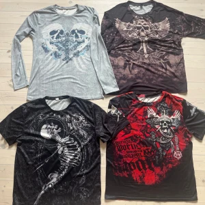 Fyra coola långärmade och kortärmade tröjor med dödskalletryck - Fyra tröjor med dödskallemotiv, en långärmade och tre kortärmade. Materialet känns som polyester och alla har en normal passform. Passar stl L (en av tröjorna står XL på). .