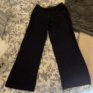 Svarta kostymbyxor First Class strl 36 - Snygga svarta kostymbyxor från First Class Collection i storlek 36. Byxorna har raka, vida ben och klassiska fickor fram. Perfekta för en clean och stilren look. Midjan är normal och det finns hällor för bälte. Helt oanvända endast testade! Skriv vid frågor💕