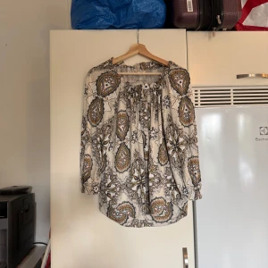 Odd molly blus  - Otroligt vacker blus i bomull och den har en vit/ cremevit bottenfärg. Blusen har svart, gul, beige och orange detaljerat mönster. Några enstaka knappar vid urringningen. Storlek 1 som enligt deras storleksguide motsvarar en storlek S. Men den är rymlig i storlek. Passar säkert en M. SAMPLE. Mycket fint skick, jag hittar inga synliga anmärkningar eller defekter.