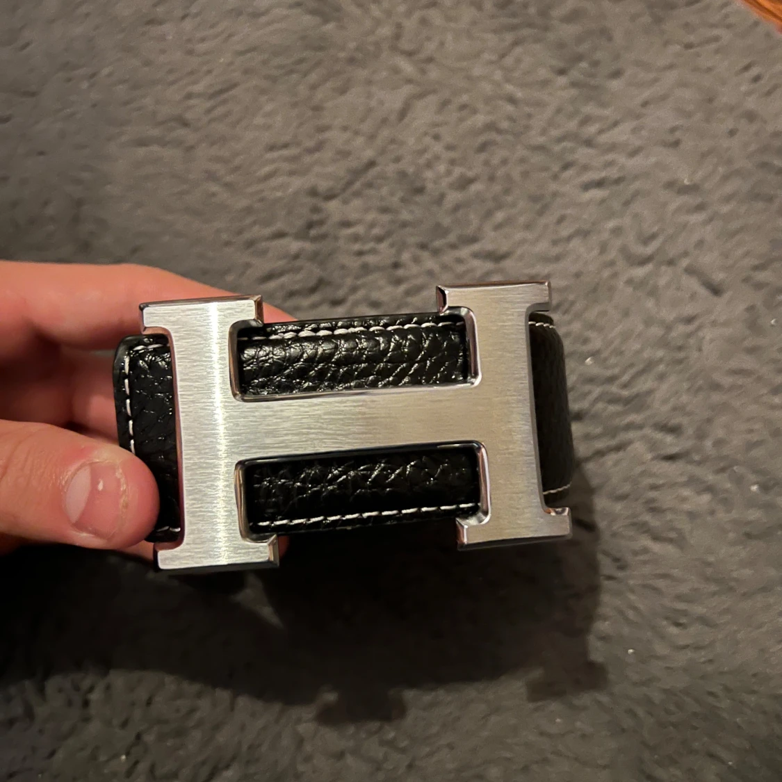 Snyggt svart bälte med ett H märke