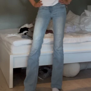 Ljusblå lowwaist bootcut jeans - Säljer ett par lågmidjade ljusblå bootcut jeans från Nelly med klassisk femficksdesign och snygga broderade detaljer på bakfickorna. Jeansen har låg midja och är tillverkade i mjukt denimtyg som sitter skönt. ❤️