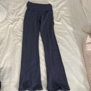 Mörkblå stickade yogabyxor från Gina Tricot - Mörkblå stickade yogabyxor från Gina Tricot med bred ribbad midja. Byxorna är bootcut i modellen och är gjorda i mjukt stickat material som är skönt mot huden. Perfekta för chill dagar eller när du vill ha en comfy look. Lite noppriga men inget man tänker på🫶🏼