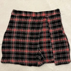 Rutig kortkjol från LELA i röd och svart - Säljer en fin rutig short/ kjol. Det står L men jag tycker det passar M mer. Fråga mig om ni undrar något!