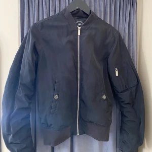 Svart bomberjacka från Crocker XS - Snygg svart bomberjacka från Crocker i storlek XS. Jackan har några fläckar på sig som borde gå bort i tvätten. Se bild. 