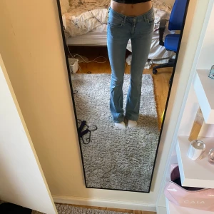 Bootcut ljusblå jeans  - Säljer ett par ljusblå lågmidjade bootcut jeans i storlek xs full lenght. Jeansen är i bra skick bara att de är lite slitna se bild 5 och slitna där ner vid ena foten. Skriv för fler bilder 