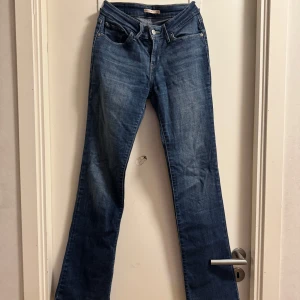 Levi's 815 Curvy Bootcut jeans blå - Säljer ett par klassiska blå Levi's 815 Curvy Bootcut jeans i storlek w27. Jeansen har en bootcut-passform och är tillverkade i slitstarkt denim. Perfekta för dig som gillar en tidlös och bekväm stil.