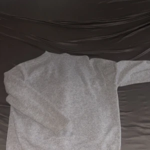 Grå hoodie med dragkedja från Saytiss - Säljer en ljusgrå hoodie från Saytiss i storlek M. Tröjan har dragkedja framtill, huva och två fickor. Perfekt för en avslappnad stil och enkel att matcha med det mesta.