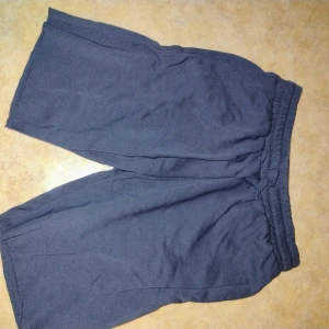 Mörkgrå shorts från H&M - Mörkgrå shorts från H&M med resår i midjan. Klassisk och enkel design utan synliga detaljer eller mönster. Perfekta för en avslappnad stil under varmare dagar.
