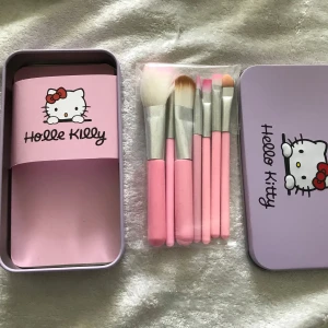 Hello Kitty sminkborstar i plåtask - Set med fem sminkborstar i olika storlekar och former med rosa och vita borst samt rosa handtag. Levereras i en söt ljuslila plåtask med Hello Kitty-motiv. Perfekt för att applicera ögonskugga, highlighter och rouge.  89kr/paket 