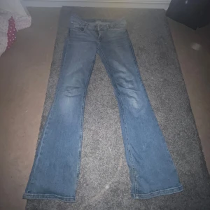 Blå bootcut jeans - Säljer ett par klassiska blå bootcut jeans med normal passform. De har en traditionell knapp- och dragkedjestängning samt bälteshällor. Är från lager 157
