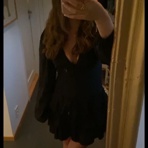 Svart volangklänning med v-ringning - Kort svart klänning med långa ärmar