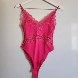 Rosa spetsbody från Zara - Säljer en rosa body från Zara med tunna axelband och vackra spetsdetaljer framtill. Använd 1 gång. 