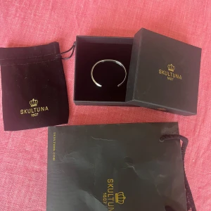 Skultuna Icon Cuff Armband silvrigt  - Jag säljer detta snygga, och tidslösa slivriga matte armband ”Icon Cuff” från Skultuna. -54mm- och relativt anpassningsbart. Passar bäst för något smalare handleder men passar generellt de flesta. Allt på bilden ingår! Skriv om frågor finns!