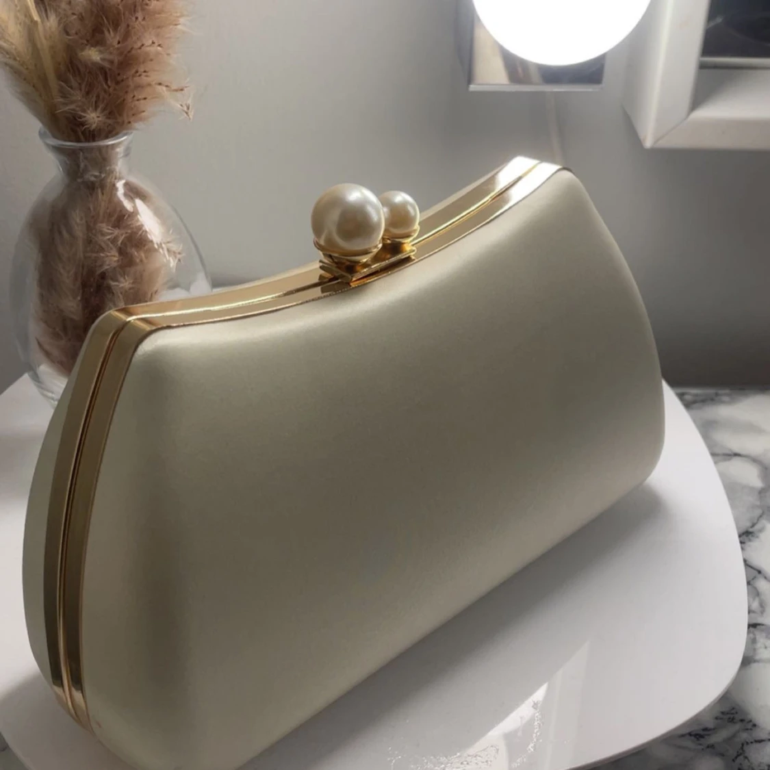 Vit kuvertväska med pärldetalj