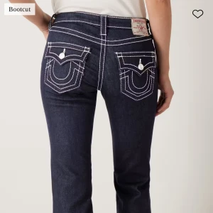 Mörkblå bootcut jeans från True Religion - Säljer ett par mörkblå bootcut jeans från True Religion med vita kontrastsömmar. Säljer då jag inte fått användning för dom. Storlek 25
