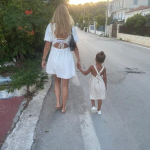 Vit kortklänning med puffärmar och öppen rygg - Superfin vit kortklänning med puffärmar och flera knytband i ryggen. Klänningen har en lätt strukturerad yta och en luftig passform, perfekt för varma dagar. Söt och trendig modell som ger en romantisk känsla.