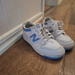 Vita New Balance sneakers med blå detaljer - Säljer ett par vita New Balance sneakers med ljusblå detaljer. Använda 1 månad