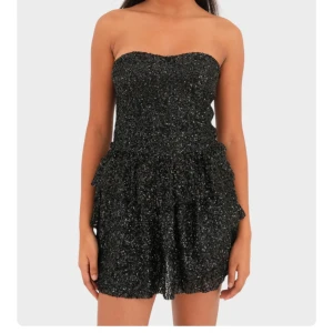 Svart glittrig klänning - Säljer en svart glittrig axelbandslös klänning  från meet me there. Klänningen är helt oanvänd och i storlek S/M.