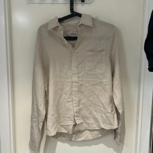 Beige linneskjorta från Dressmann - Säljer en skjort från Dressmann bra skick har använt den två gånger pris går att prata om.