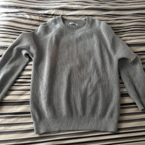 Grå stickad tröja från Zara - Säljer en stilren grå stickad tröja från Zara. Perfekt för lager-på-lager och enkel att matcha med olika outfits. Liten i storlek passar bäst för dig som har S.