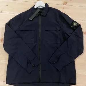 Svart overshirt jacka från Stone Island -  Den har inte kvar tagen som på bilden. Men annars nästan helt ny. Skriv vid intresse!