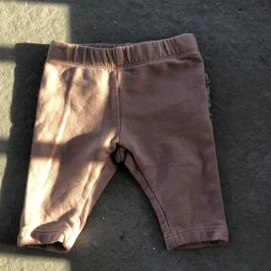 Rosa leggings med volang bak - Supersöta rosa leggings med elastisk midja och volangdetaljer baktill. Perfekta för en gullig och bekväm look till de minsta. Mjukt material som är skönt mot huden.