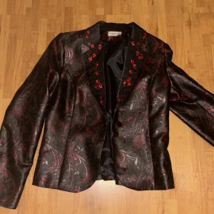 Svart, rödblommig jacka - Jackan är oanvänd, med rödblommigt mönster från märket Cemre, med en knapp för att kunna stänga jackan.